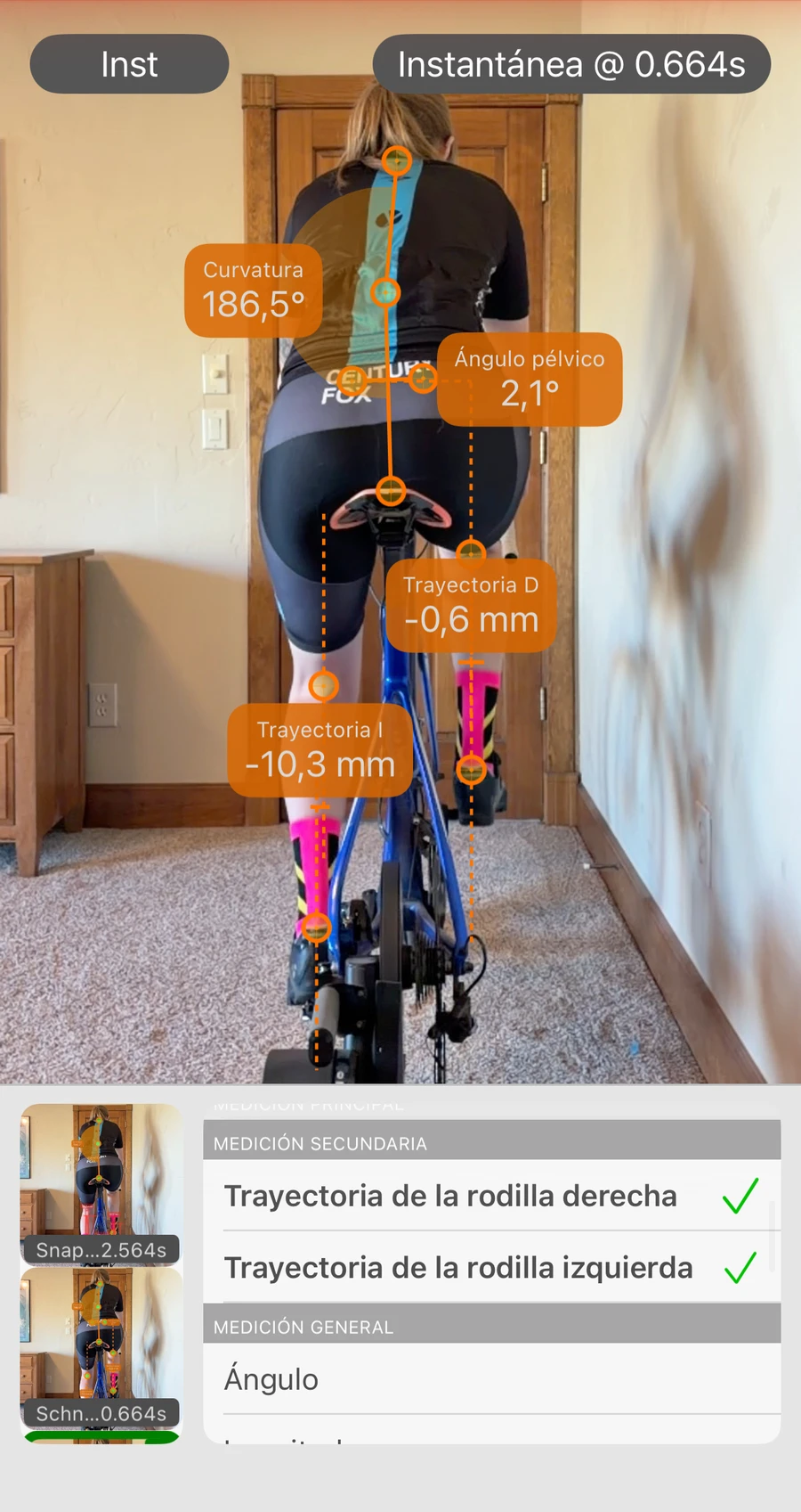 Análisis de vista trasera en Bike Fast Fit Pro: un ciclista rastreado desde atrás, con el desplazamiento lateral de cada rodilla en milímetros, el ángulo pélvico y la flexión de la espalda leídos del cuadro, y la lista de mediciones abierta debajo
