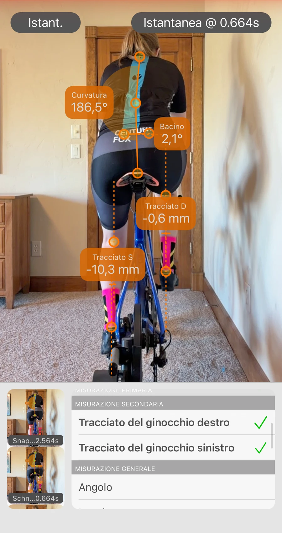 Analisi della vista posteriore in Bike Fast Fit Pro: un ciclista tracciato da dietro, con lo spostamento laterale di ciascun ginocchio in millimetri, l'angolo pelvico e la flessione della schiena letti dal fotogramma, e l'elenco delle misurazioni aperto sotto