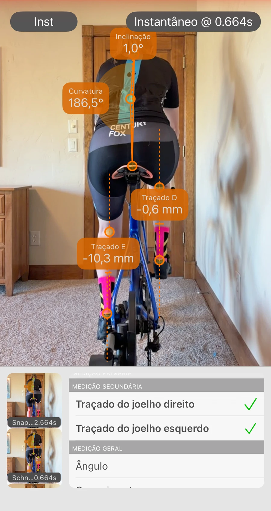 Análise da vista traseira na Bike Fast Fit Pro: um ciclista seguido pela app por trás, com o deslocamento lateral de cada joelho em milímetros, o ângulo pélvico e a flexão das costas lidos da imagem, e a lista de medições aberta por baixo